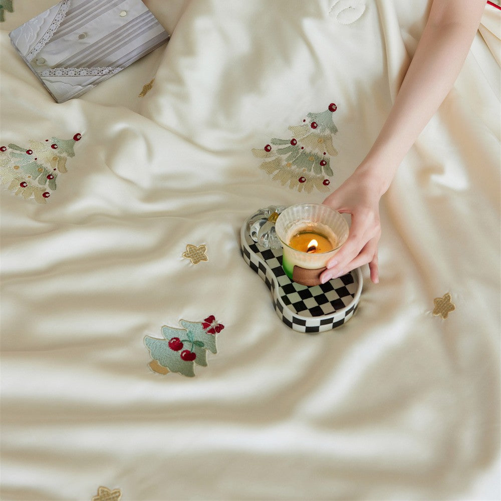 Luxurious satin bed linen set with embroidered Christmas tree motifs and contrasting piping