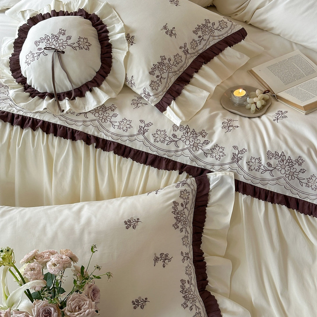 Luxurious bedding set with embroidered cover, ruffled bed skirt, and decorative pillow