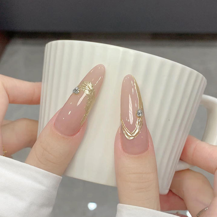 Artificial nail set with elegant gold design and sparkling applications Stornfield