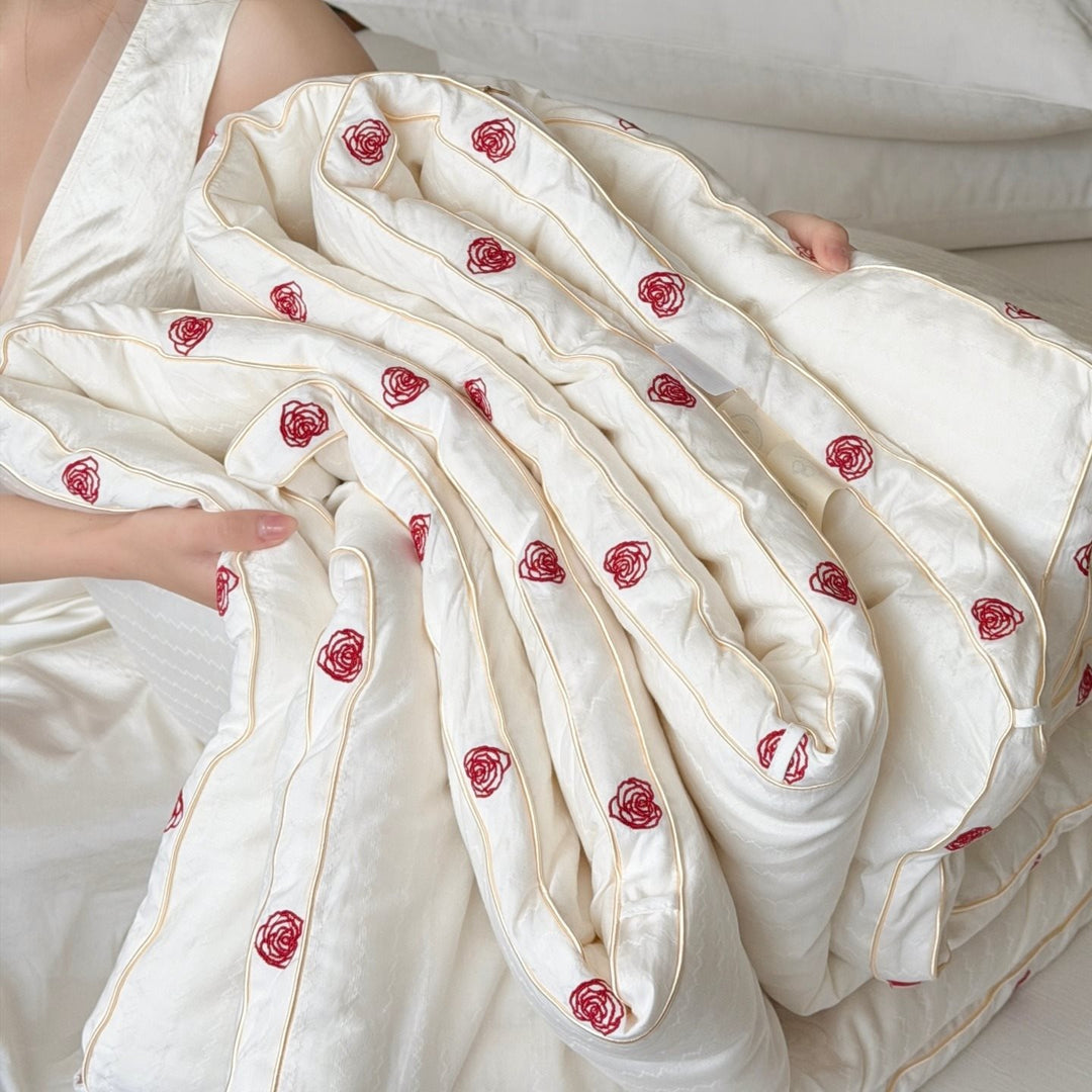 Quilt made of cotton satin with embroidered rose trim