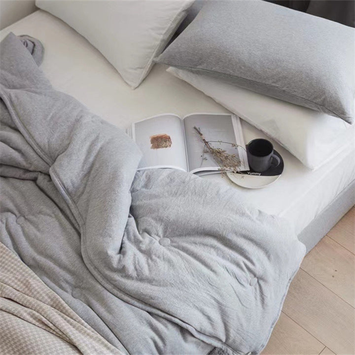 Light reversible quilted blanket made of microfiber with soft decorative stitching
