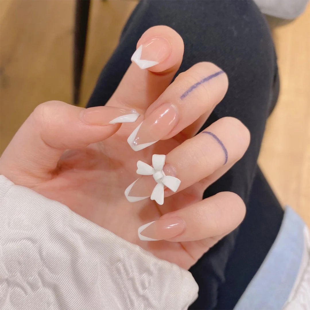 Elegant artificial nails with translucent French tip and decorative floral accents Stornfield