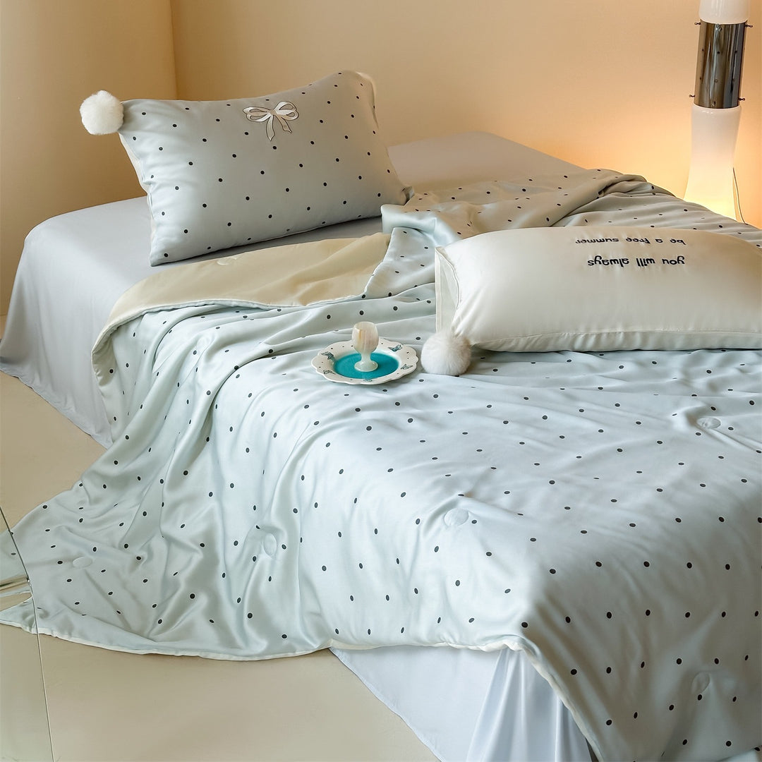 Luxurious satin bedding set with polka dot pattern and pom-pom tassels