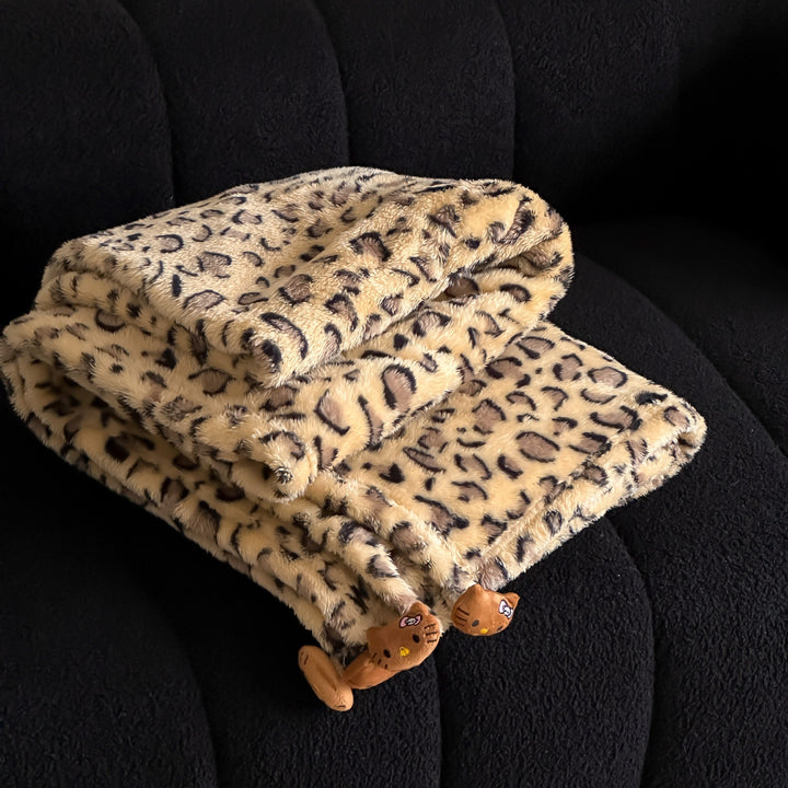 Cozy throw blanket made of microfleece with leopard print and plush pendants