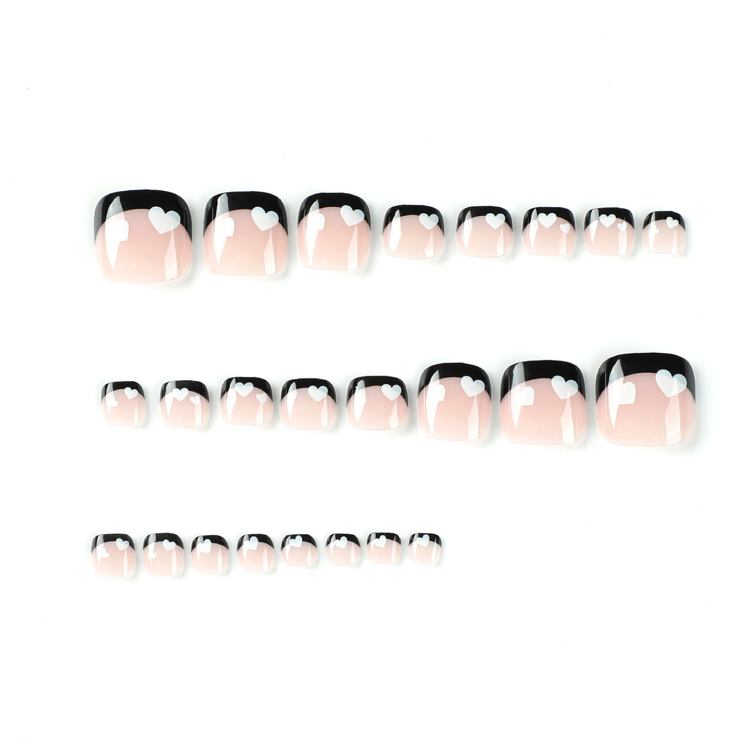 Artistic toenail design with heart motifs and modern black-and-white design Stornfield