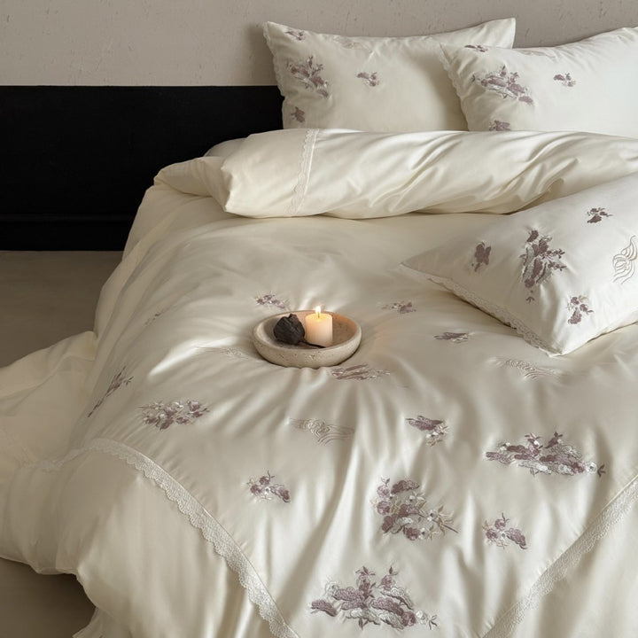 Satin bedding set with subtly embroidered flowers and lace trim