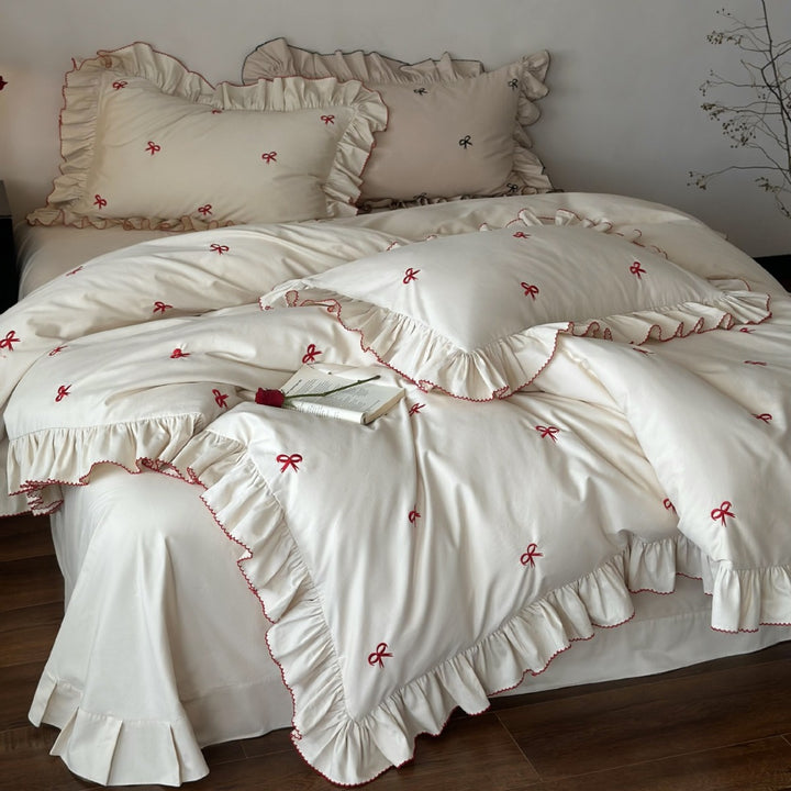 Ruffled bedding set with embroidered bows and frills