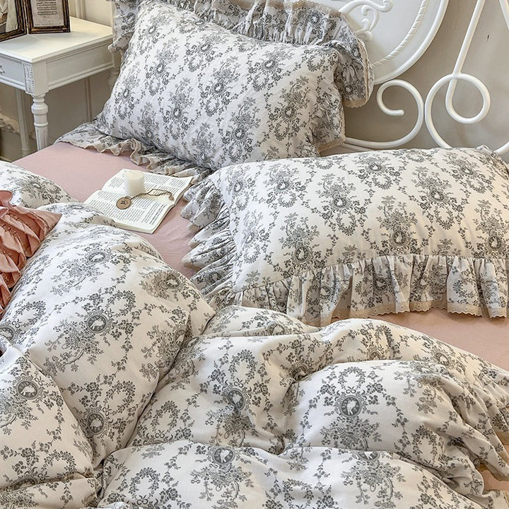Romantic quilted comforter with ruffled border and fine floral pattern