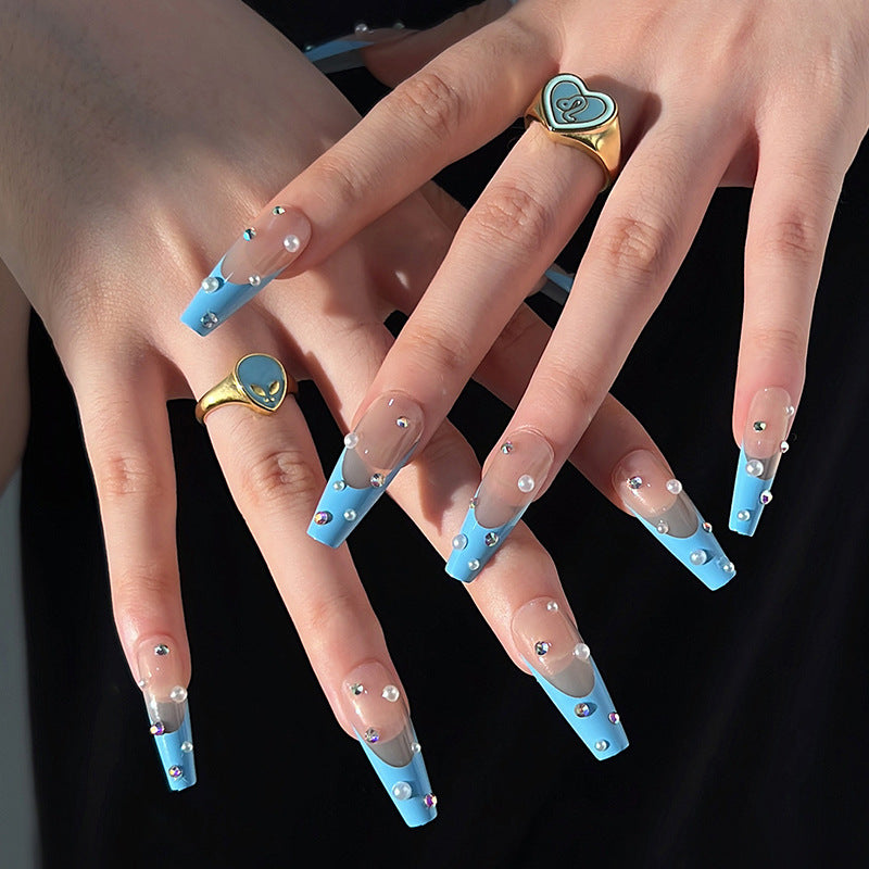 Artificial nail extensions with glitter and pearl accents Stornfield