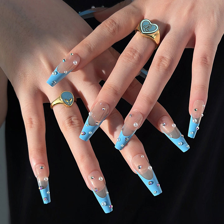 Artificial nail extensions with glitter and pearl accents Stornfield