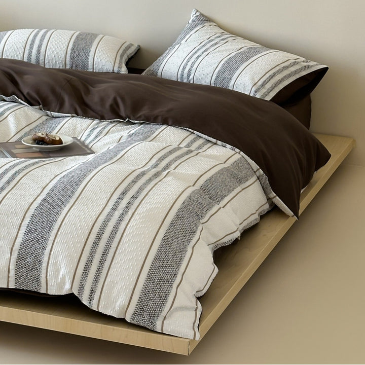 Reversible bedding set with textured striped look and fine quilting