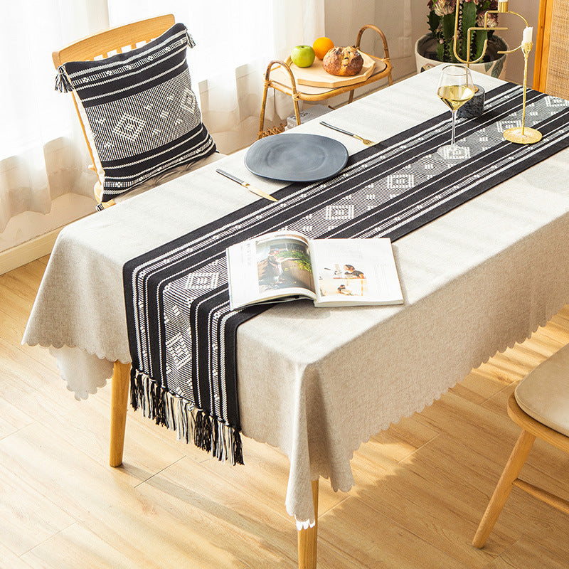 Handwoven table runner made of cotton blend with geometric weave pattern and fringe trim