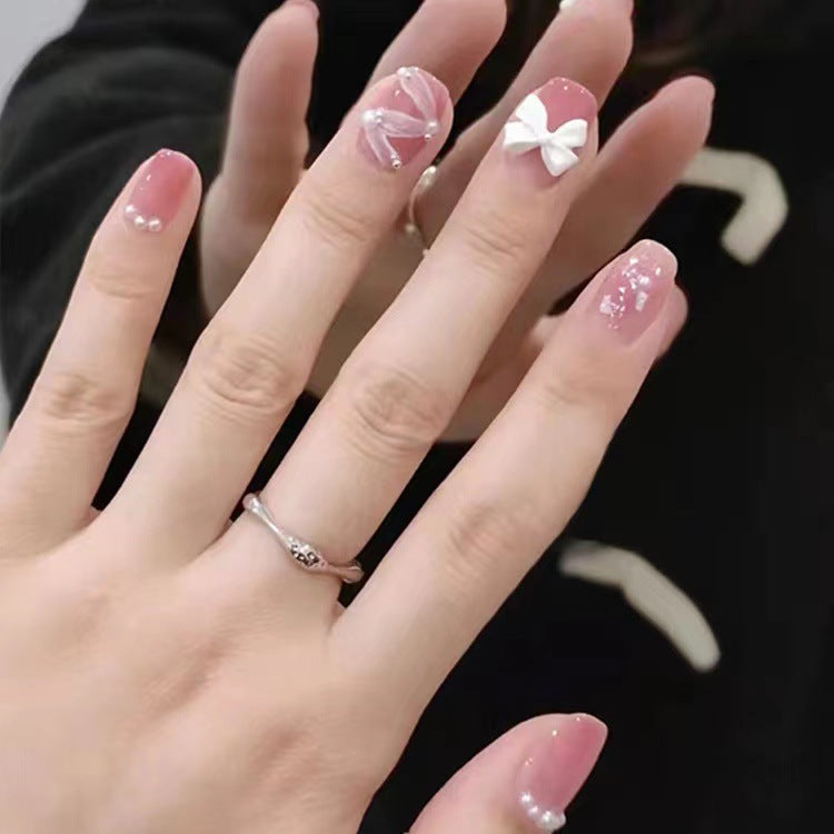 Glamorous nail art with pearl and bow accents Stornfield