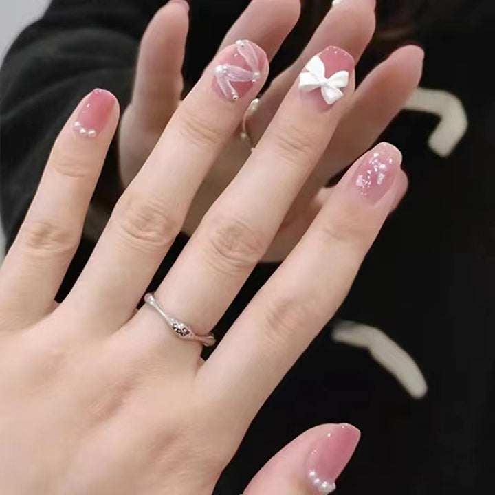 Glamorous nail art with pearl and bow accents Stornfield