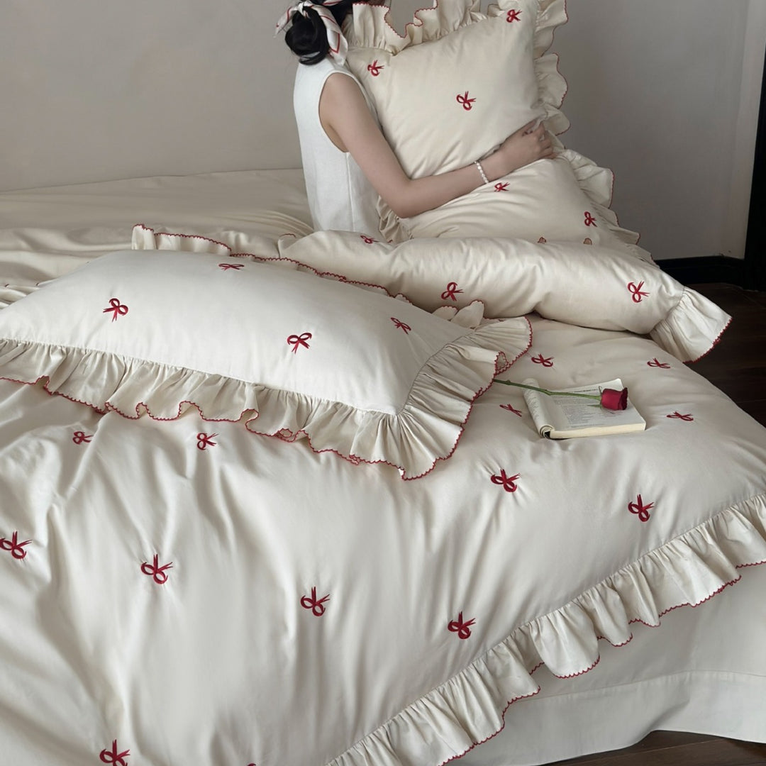 Ruffled bedding set with embroidered bows and frills