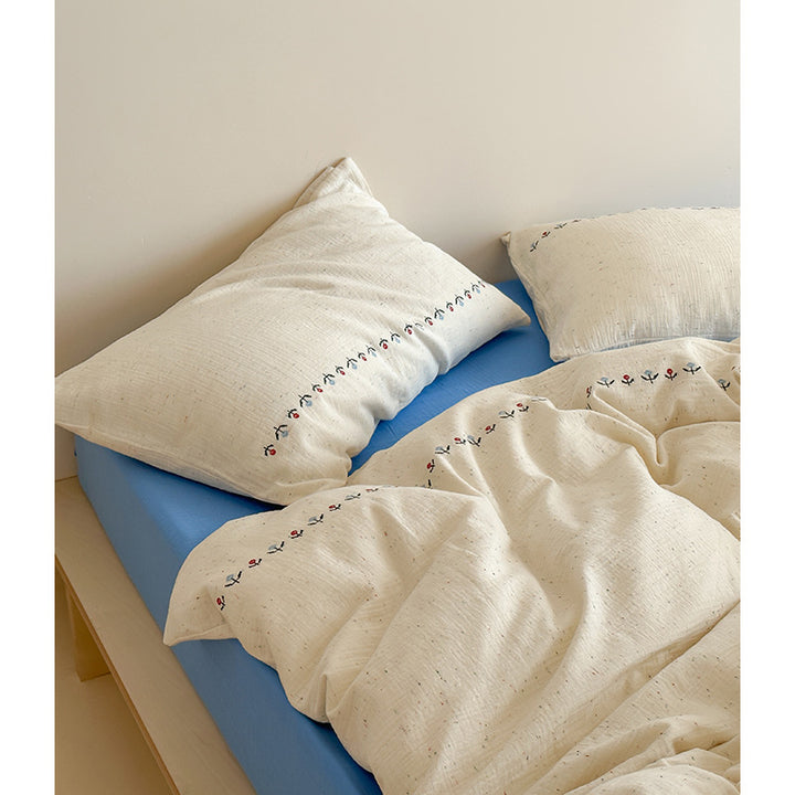 Cotton gauze bedding set with delicate border embroidery and mottled nep structure