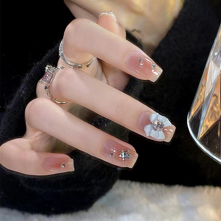 Artistic nail tips with floral and glittering accents Stornfield