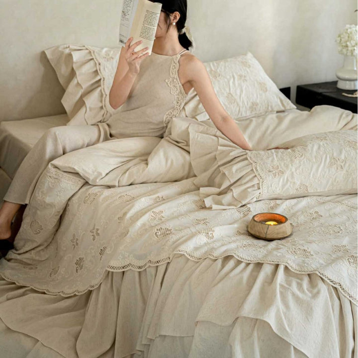 Romantic cotton bedding set in country house style with embroidered bedspread, ruffled bed skirt, and frill pillow.