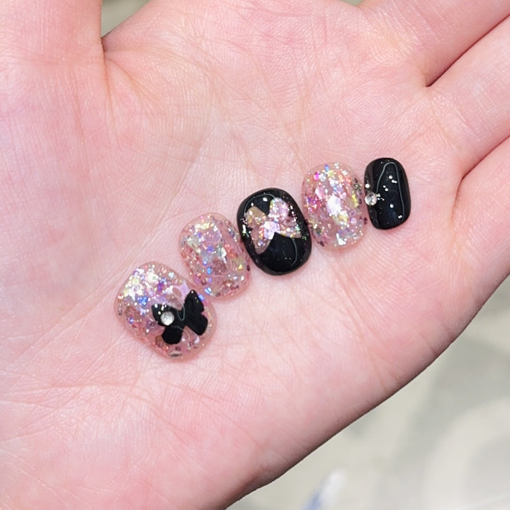 Artificial nails with glitter and bow accents Stornfield