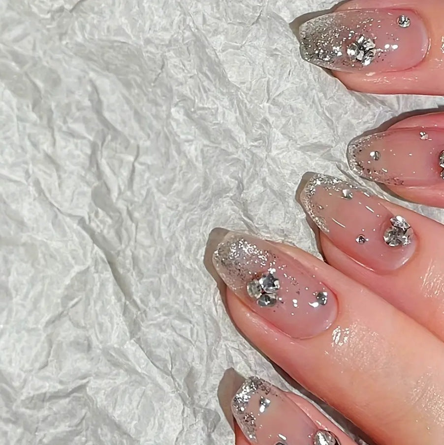 Glamorous artificial nails with glitter and rhinestone embellishments Stornfield
