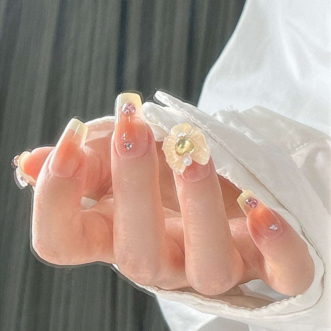 Artificial nail set with elegant floral decorations and glitter accents Stornfield