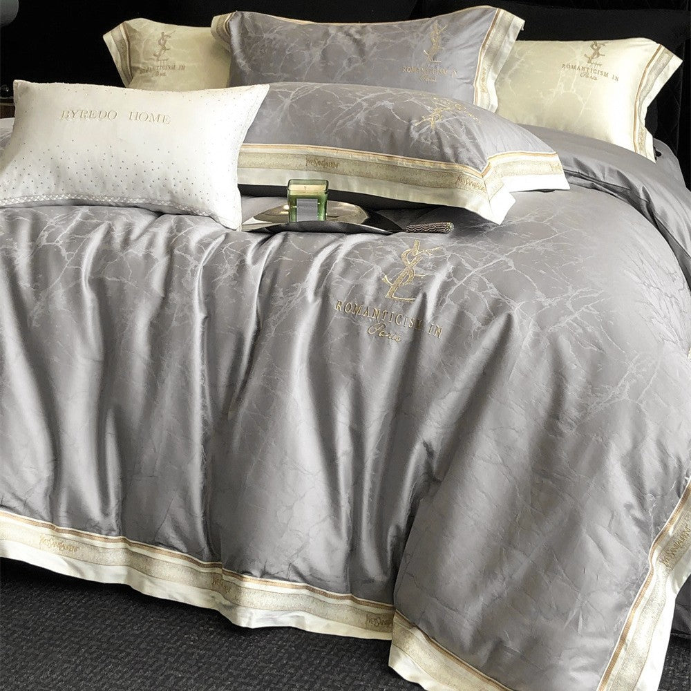 Luxurious satin bedding set with subtle marble texture and golden embroidered border