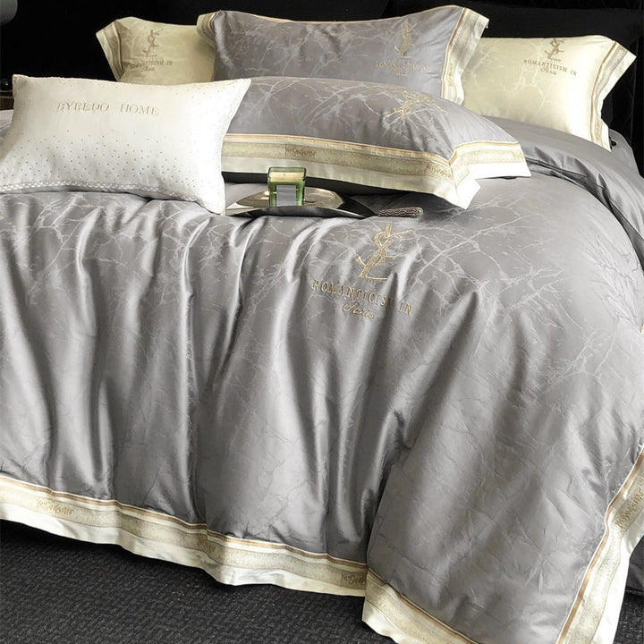 Luxurious satin bedding set with subtle marble texture and golden embroidered border