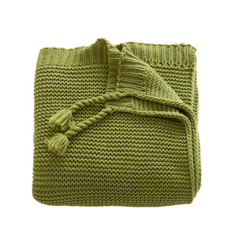 Chunky knitted cozy blanket with diamond pattern and colorful knots