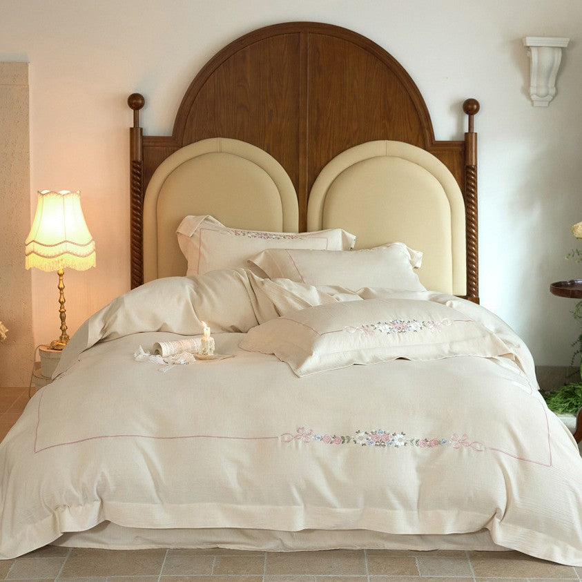 Romantic cotton satin duvet cover set with delicate floral embroidery and decorative pillow