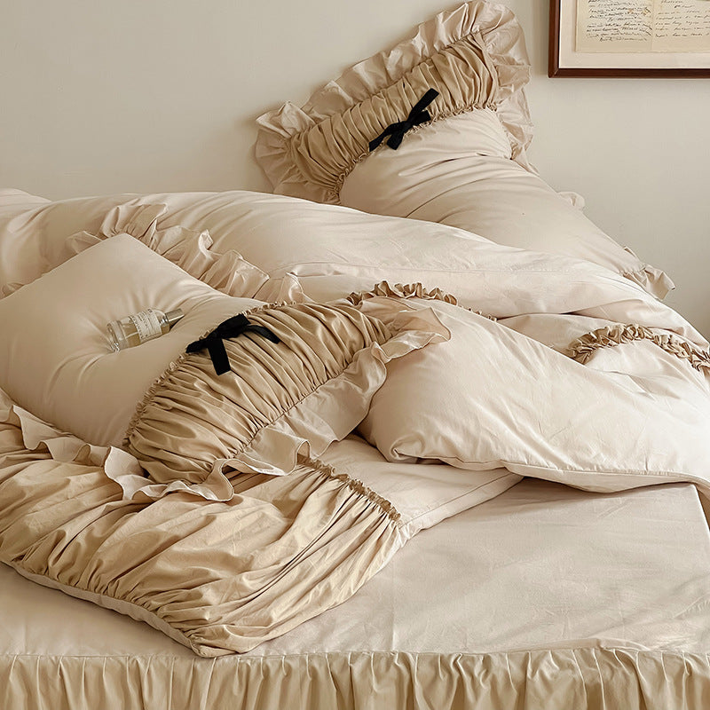 Luxurious satin bedding set with gathered ruffle, braided decorative ribbons and bow appliqué