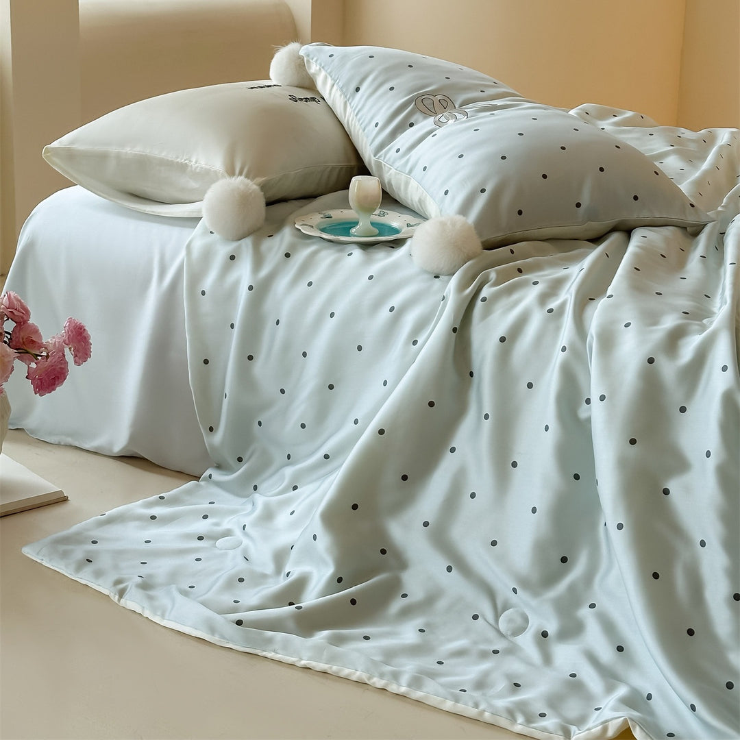 Luxurious satin bedding set with polka dot pattern and pom-pom tassels