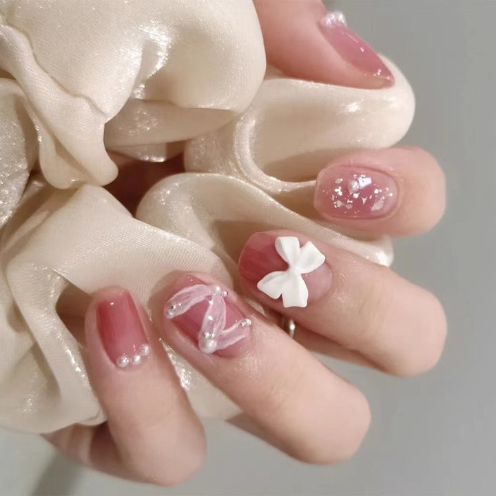 Glamorous nail art with pearl and bow accents Stornfield