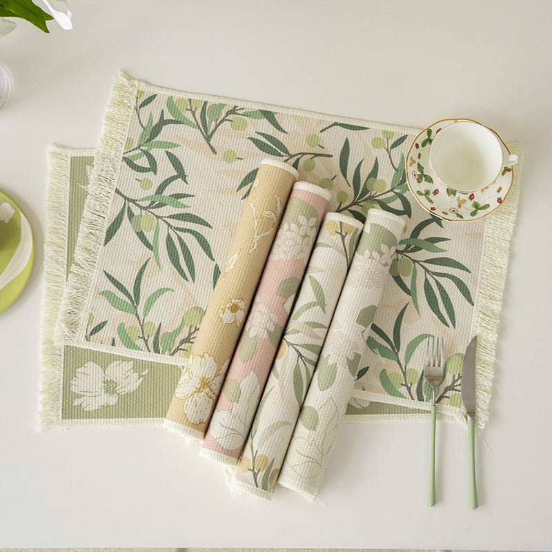 Woven table placemat made of cotton blend with olive branch print and decorative fringe edge