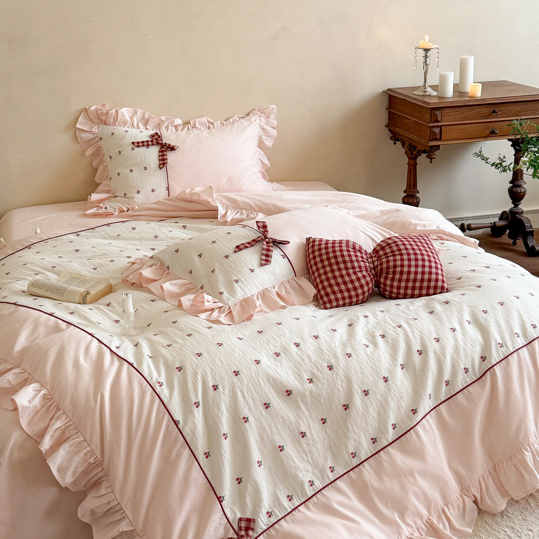 Playful ruffled bed set made of cotton muslin with embroidered cherries and checkered bows
