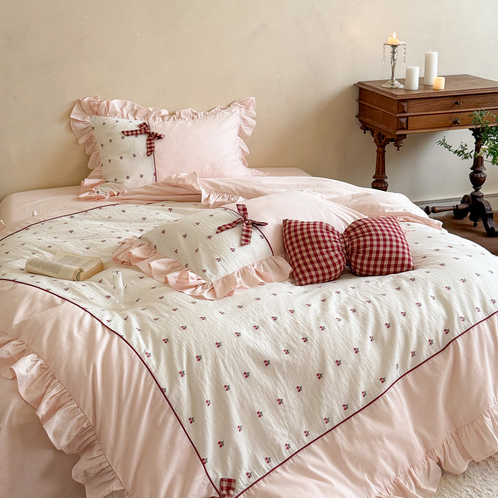 Playful ruffled bed set made of cotton muslin with embroidered cherries and checkered bows