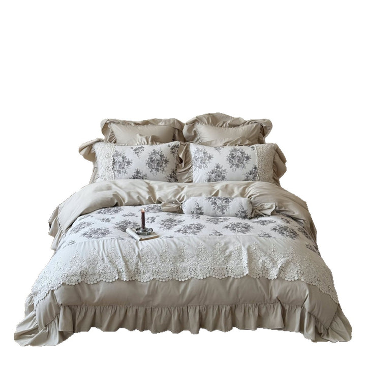 Bedding set in French country house style with lace trim, ruffled bed skirt, and subtle toile floral design