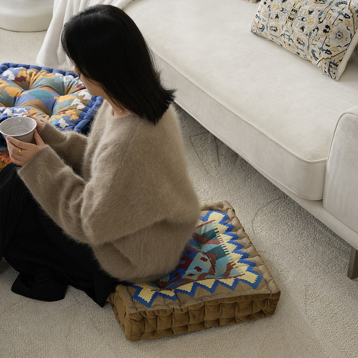 Square seat cushion with kilim-inspired pattern, quilted padding and carrying handle