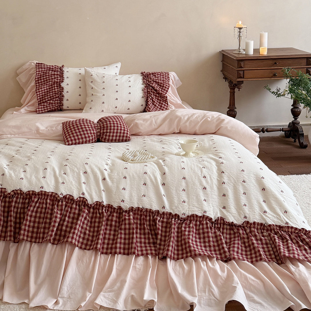 Playful ruffled bed set made of cotton muslin with embroidered cherries and checkered bows