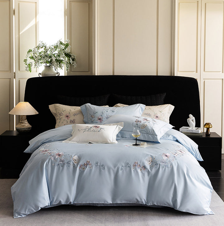 Luxurious embroidered satin bed linen set with floral corner motif and contrast piping