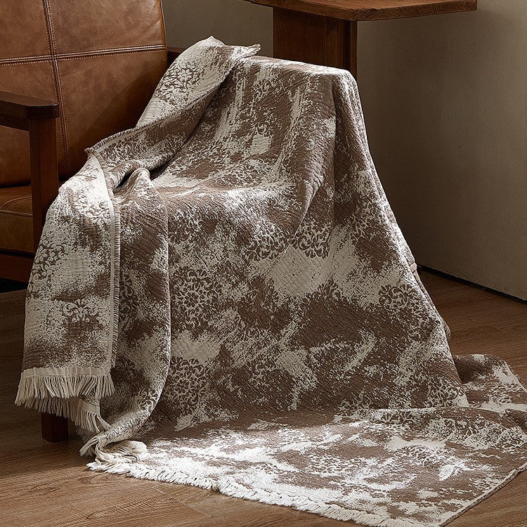 Large cozy living blanket made of cotton blend fabric with geometric jacquard pattern and fringed hem