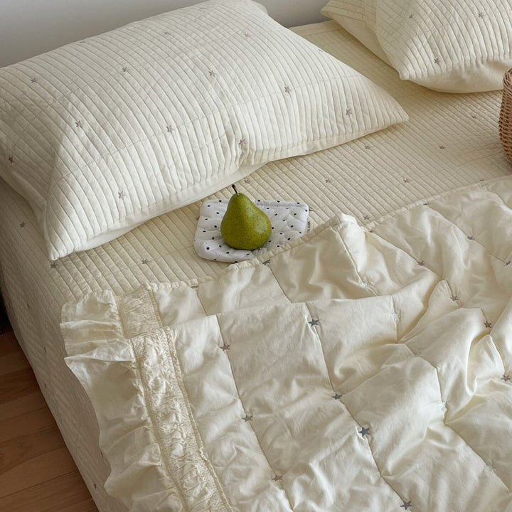 Quilted bedspread with delicate longitudinal stitching and matching pillowcases