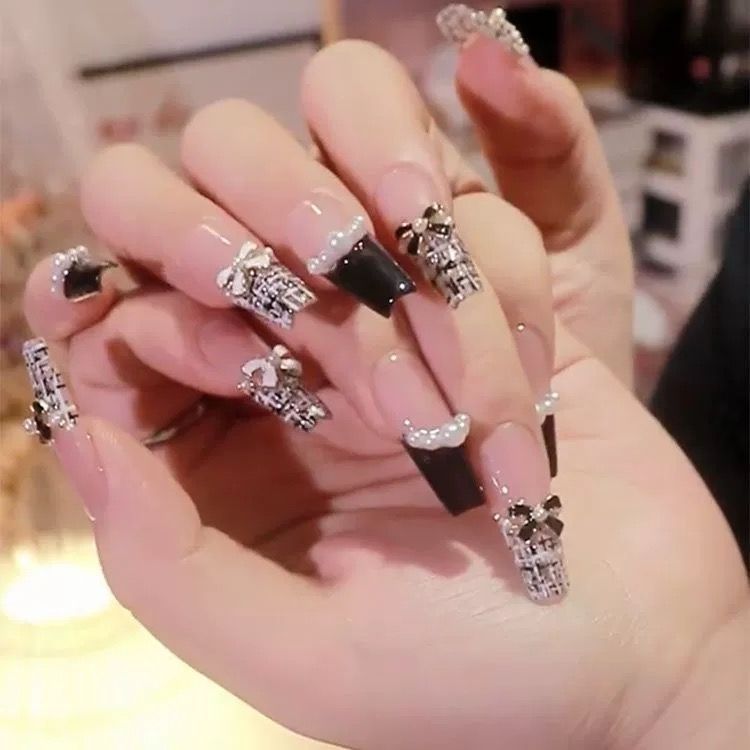 Artistic Nail Art with Glitter and Flower Applications Stornfield