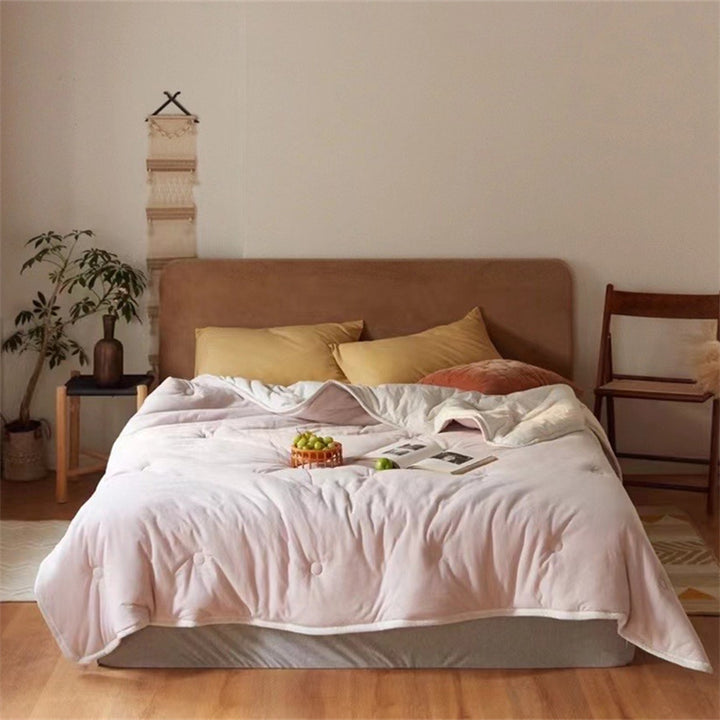 Light reversible quilted blanket made of microfiber with soft decorative stitching