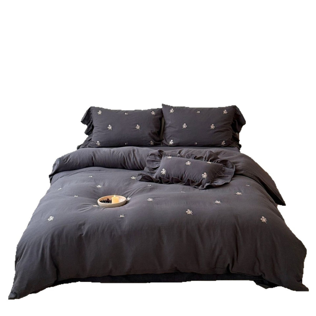 Cotton satin bedding set with delicate embroidered flowers, ruffled decorative pillow, and hotel closure Stornfield