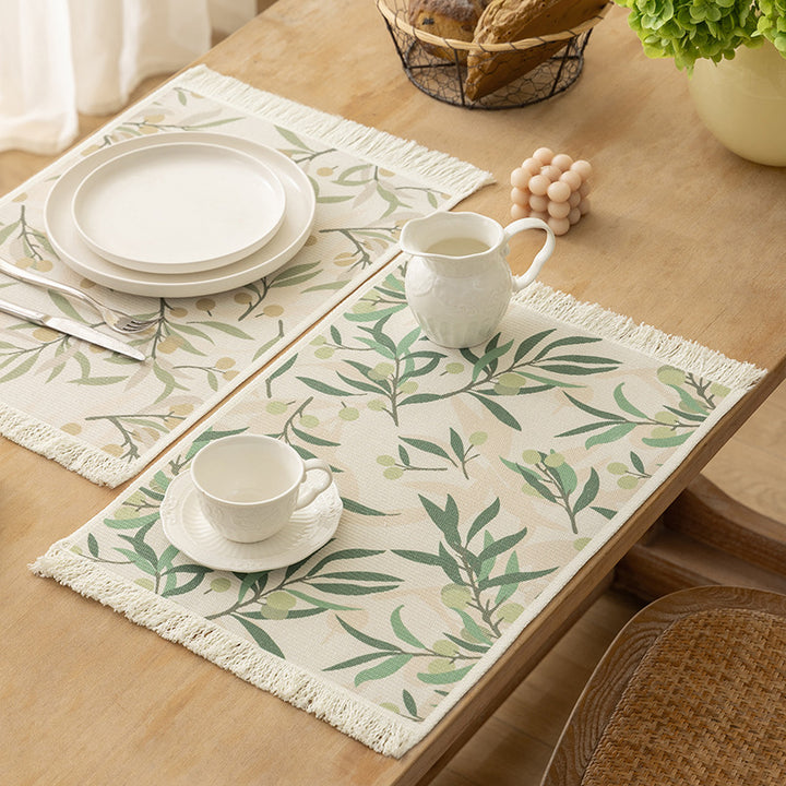 Woven table placemat made of cotton blend with olive branch print and decorative fringe edge