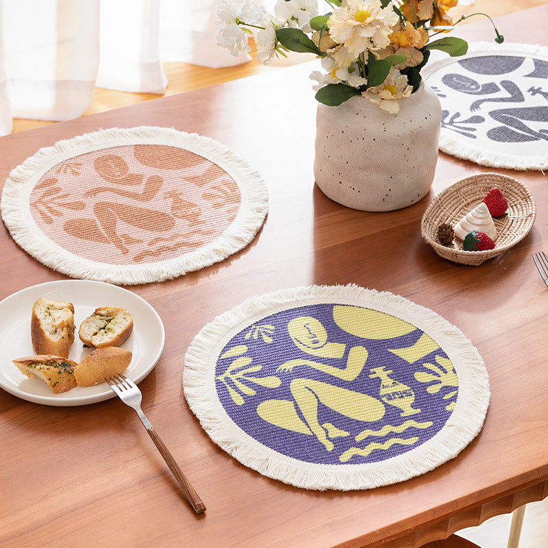 Round woven placemat with fringes and abstract figure motif Stornfield