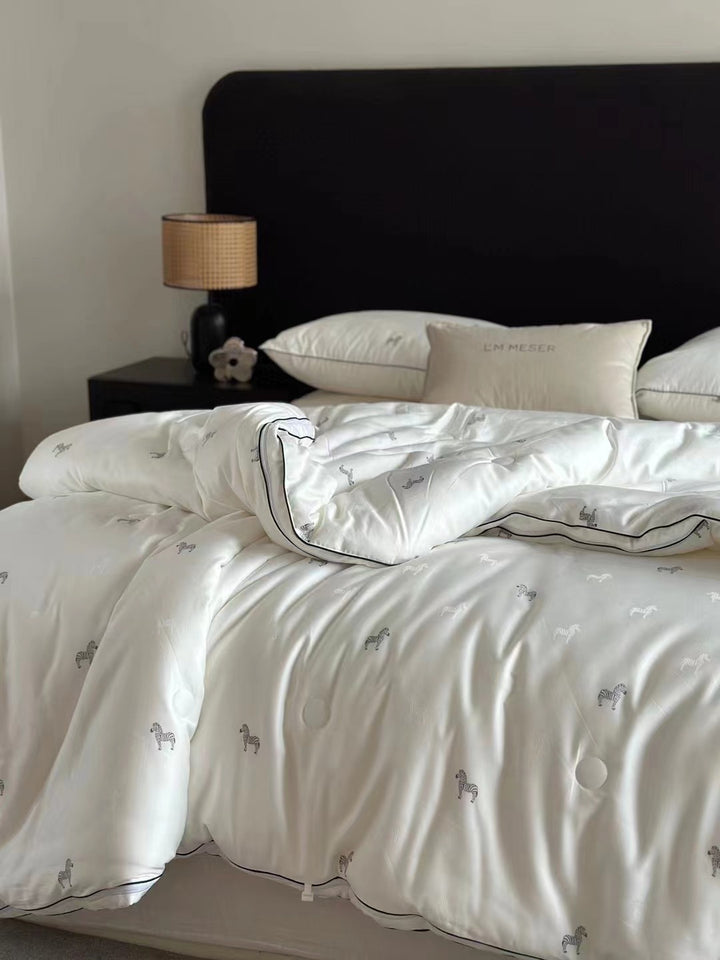 Light-warming cassette comforter with hollow fiber filling and fine tonal embroidery