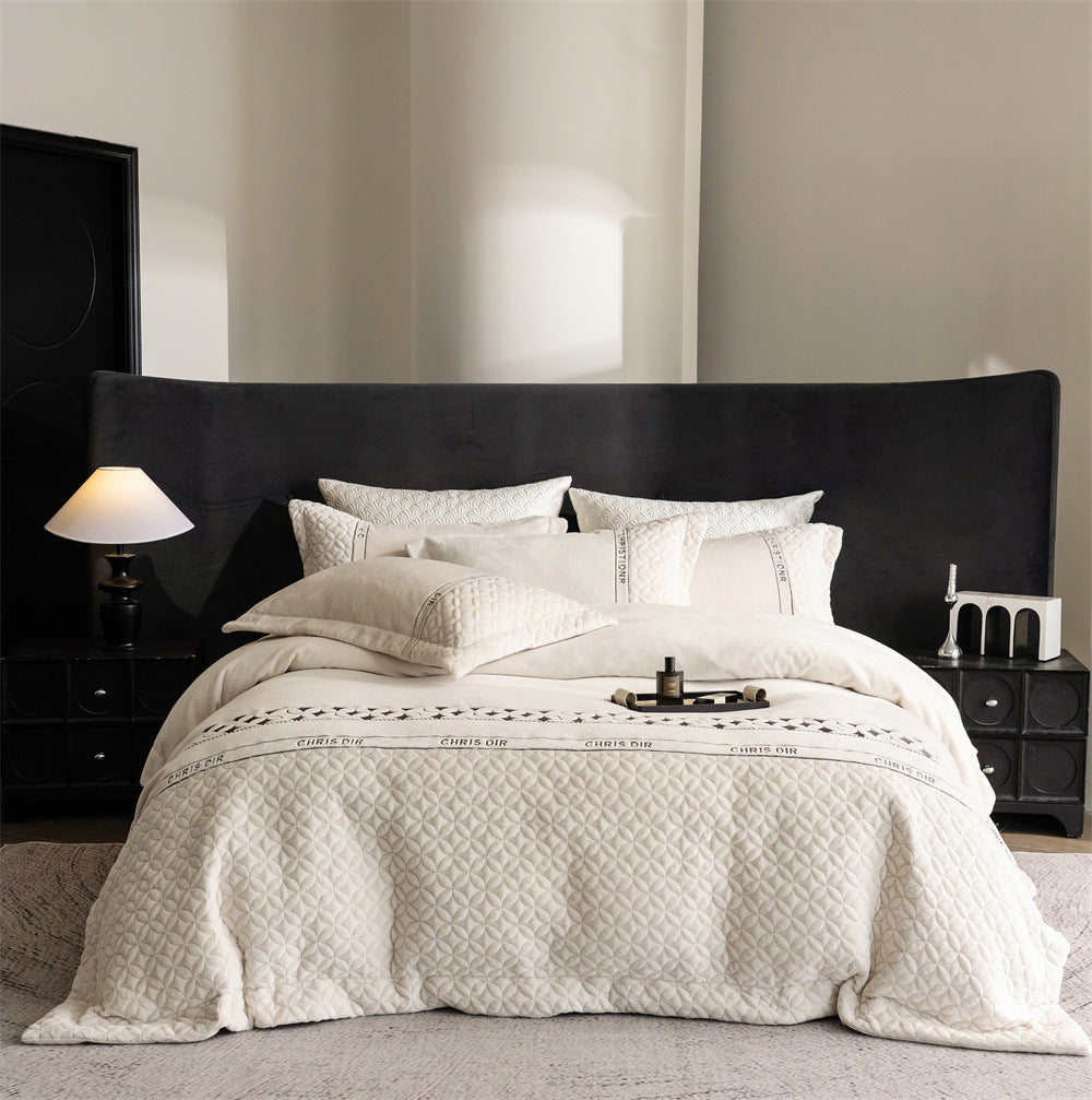 Quilted bedding set with geometric quilting and decorative ribbon