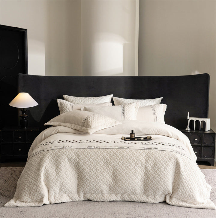 Quilted bedding set with geometric quilting and decorative ribbon