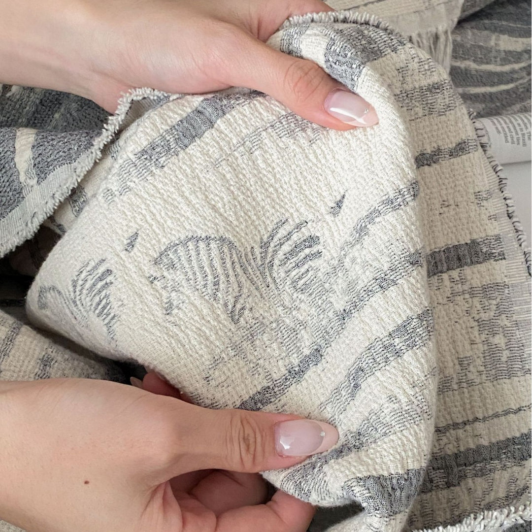 Cozy living blanket made of cotton blend fabric with fringes and striped texture